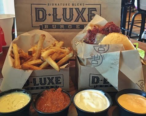 D-Luxe Burger's El Diablo burger, small fries, and various dipping sauces